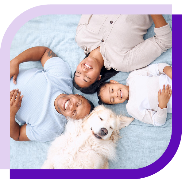 image of a family and a dog lying on a bed